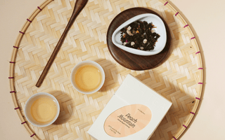 Two cups of oolong tea beautifully displayed on a traditional woven bamboo tray to show the classic and traditional luxury of O2H TEA as well as to emphasise the pure quality of O2H tea.