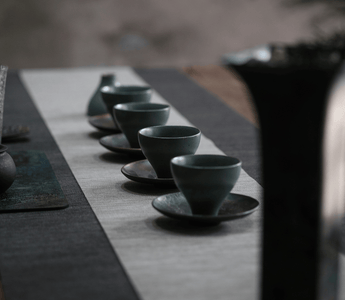 Tea ceremony setup with traditional ceramic tea cups arranged on a table, showcasing the cultural heritage and artistry of tea rituals.