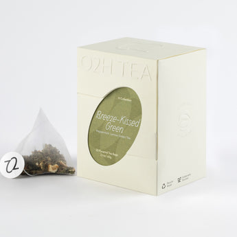 Peppermint Lemon Green Tea packaged in an off-white box with a visible tea bag revealing vibrant green tea and lemon zest.