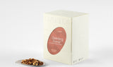 Box of Cederbergs Sunrise Rooibos Tea beside a sample of its citrus-infused lemongrass and grapefruit blend on a plate.