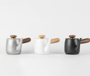 Trio of O2H TEA pots in silver, white, and black, combining minimalist design and functional elegance for a superior tea steeping experience.