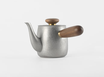 O2H TEA's modern stainless steel teapot with wooden accents, blending form and function for an elegant tea steeping experience.