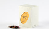 Hawthorn Pu-erh Tea box beside a pile of its blend showcasing dark pu-erh leaves and vibrant red hawthorn berries.