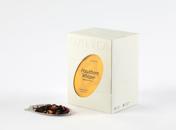 Hawthorn Pu-erh Tea box beside a pile of its blend showcasing dark pu-erh leaves and vibrant red hawthorn berries.