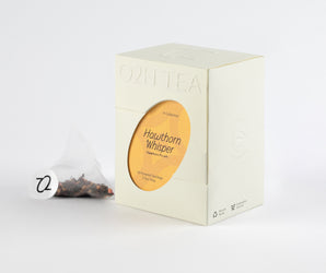 Hawthorn Pu-erh Tea box and transparent tea bag showcasing a blend of pu-erh leaves and hawthorn pieces.