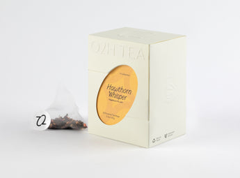 Hawthorn Pu-erh Tea box and transparent tea bag showcasing a blend of pu-erh leaves and hawthorn pieces.