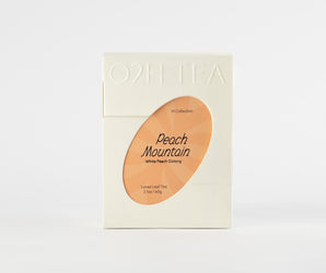 White Peach Oolong Tea in an elegant white package, featuring a transparent window showcasing the product name Peach Mountain