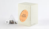 A box of White Peach Oolong Tea displaying with a tea bag filled with aromatic oolong tea leaves and peach pieces.